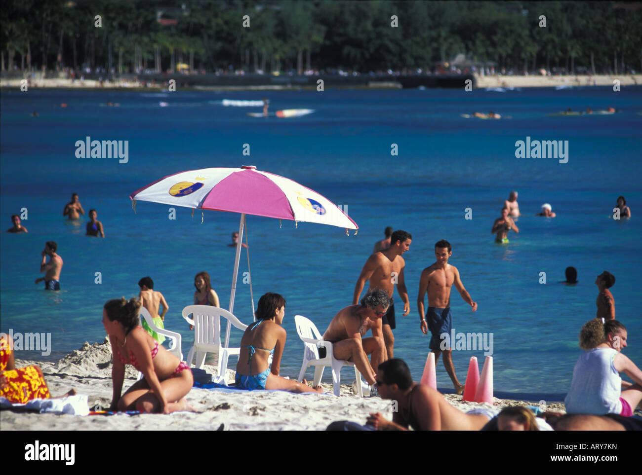Le persone in vacanza amano la sabbia, sole e acque blu offerti presso la spiaggia di Waikiki. Foto Stock