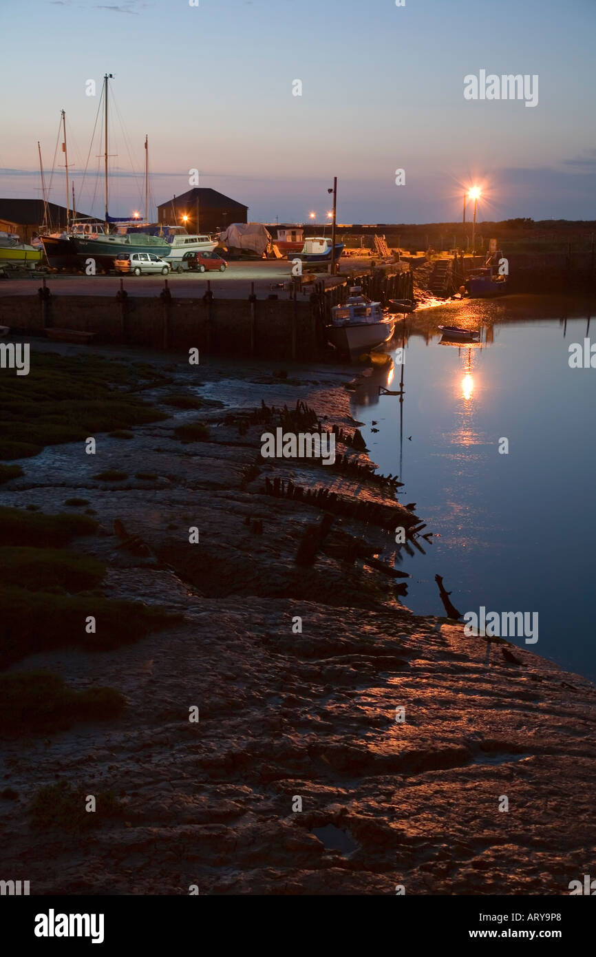 Riflessi di luci sulla banchina di fango di marea foce del fiume Clwyd al crepuscolo Rhyl Wales UK Foto Stock