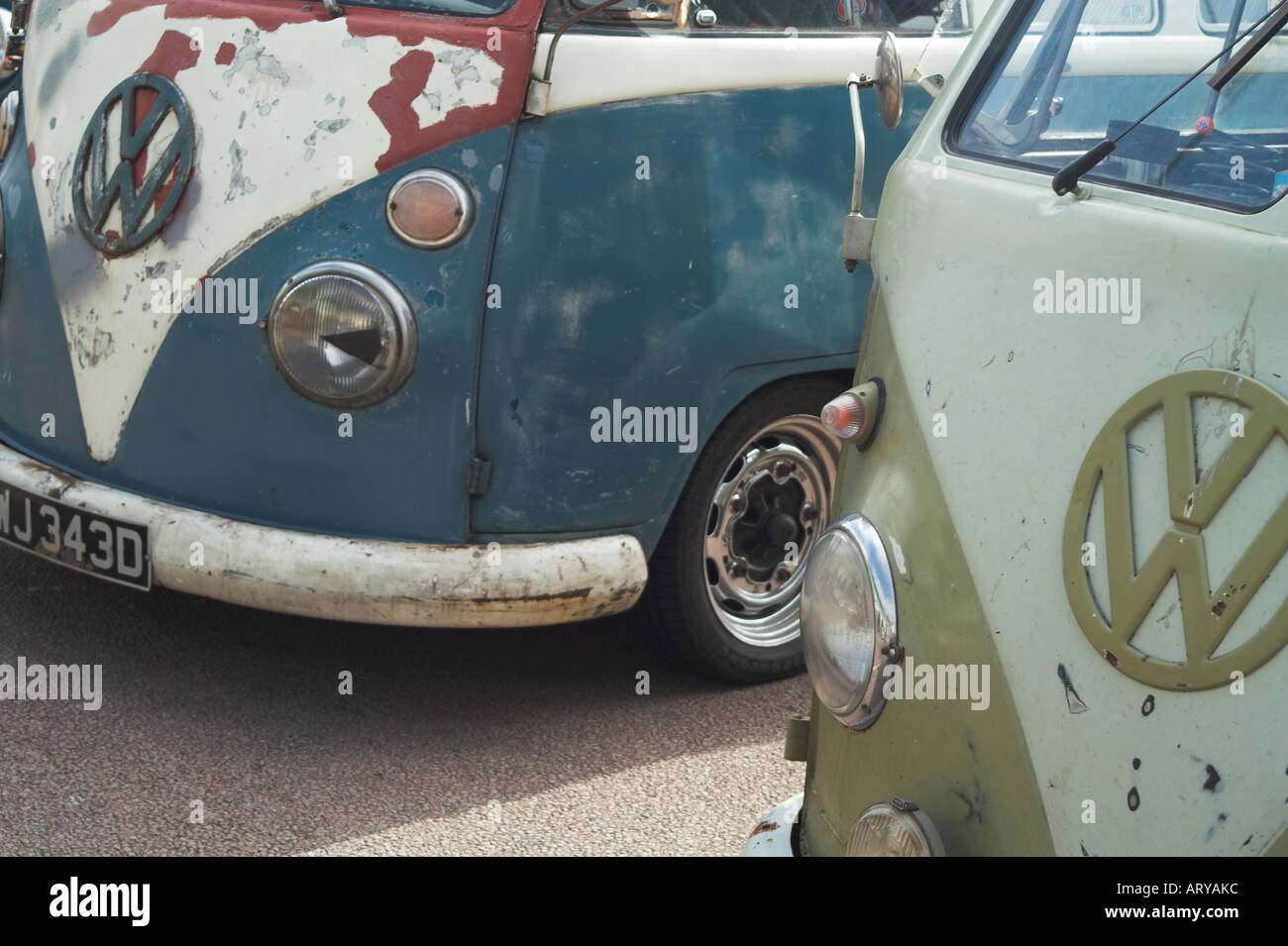 Una coppia di scruffy rusty Volkswagen VW tipo 2 split camper. Foto Stock