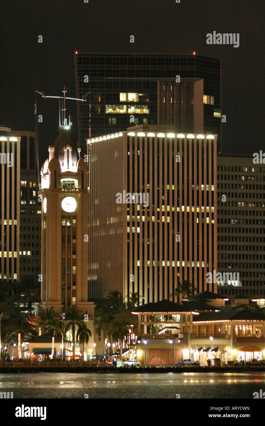 Notte foto di Aloha Tower e Aloha Tower marketplace lungo il Porto di Honolulu. Downtown Honolulu in background. Oahu. Foto Stock