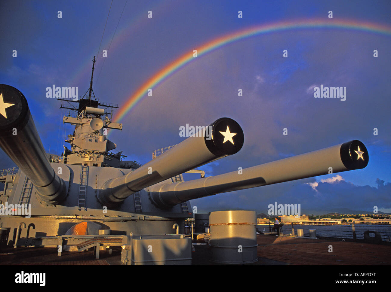 U.S.S Missouri riposa serenamente nel porto di perla come un museo galleggiante di WWII storia navale. Un colorato hawaiian rainbow brilla Foto Stock