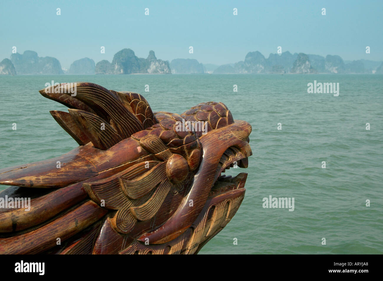 Un dragone in legno prua guardando alla baia di Halong con le sue 3000 isole e isolette di carbonifero chalk. Foto Stock