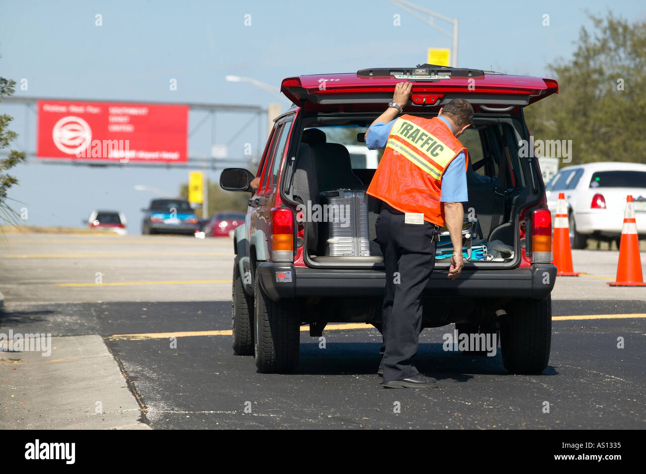 Sicurezza patrolman ispeziona il veicolo su di esso s modo per il terminal aeroportuale Foto Stock