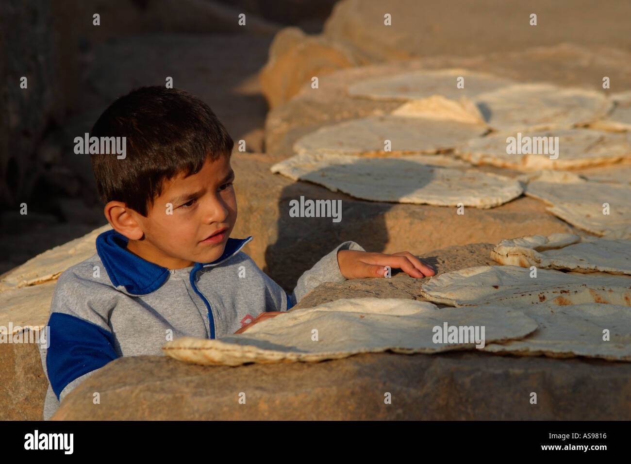 Ragazzo pane di asciugatura sulla sommità delle colonne romane di Bosra Foto Stock