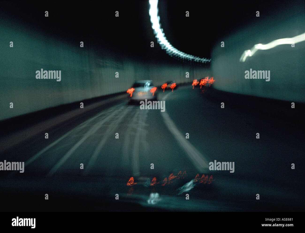 Strada e il traffico blur come corse in auto attraverso un tunnel Foto Stock