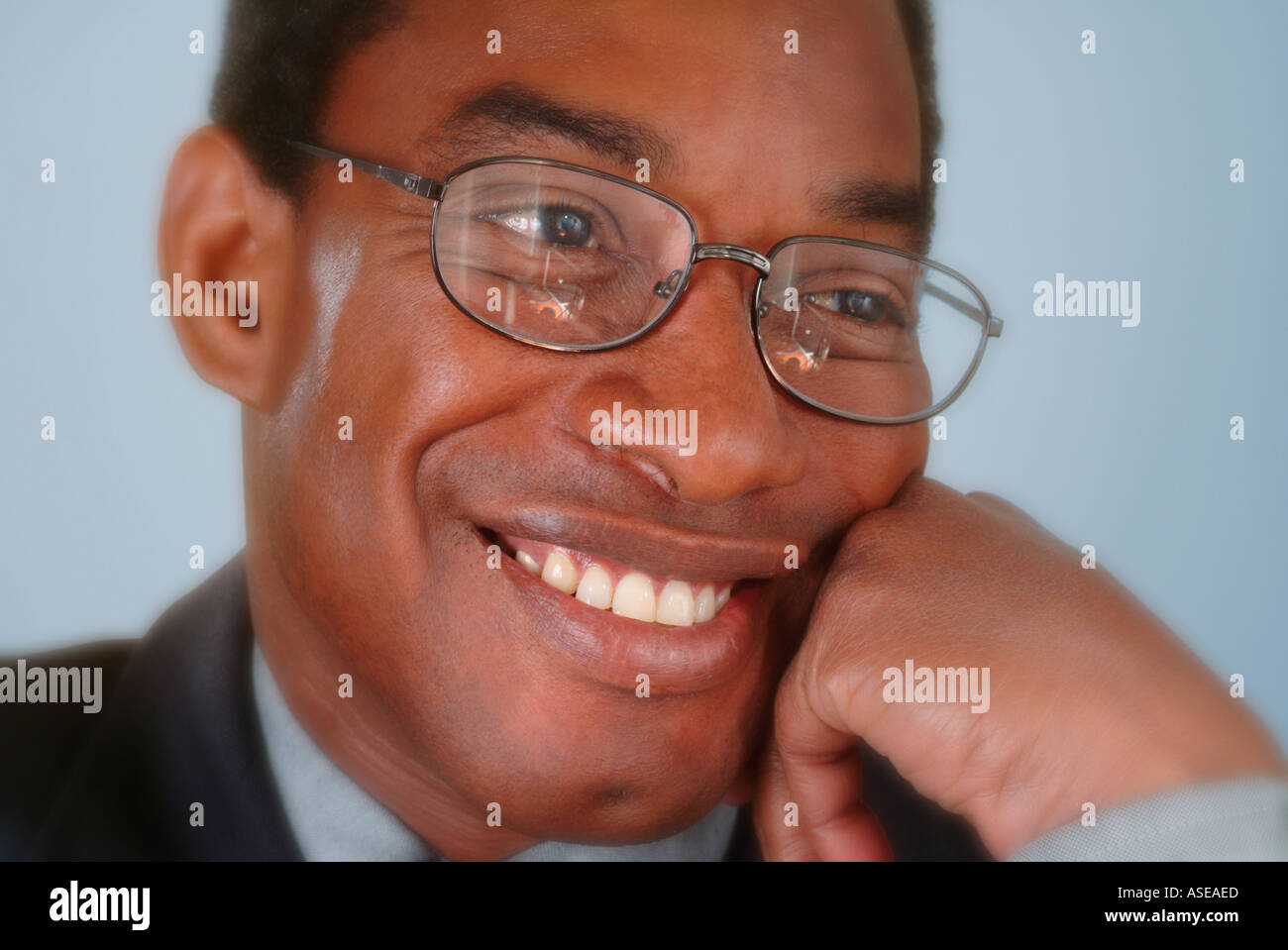 Un imprenditore di nero che indossano occhiali sorridente in un ritratto Foto Stock