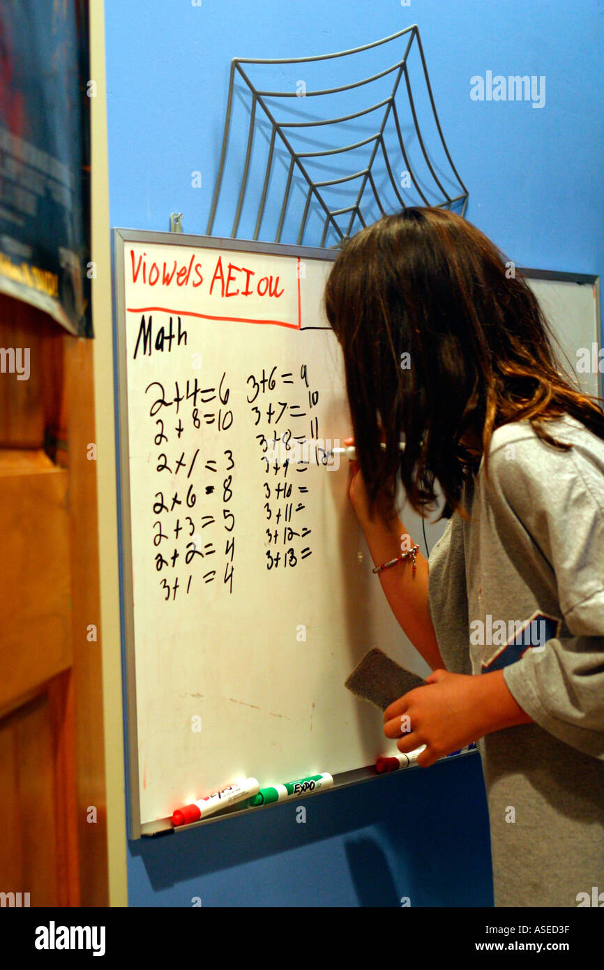 Ragazza giovane lavorando sul problema di matematica a casa Foto Stock