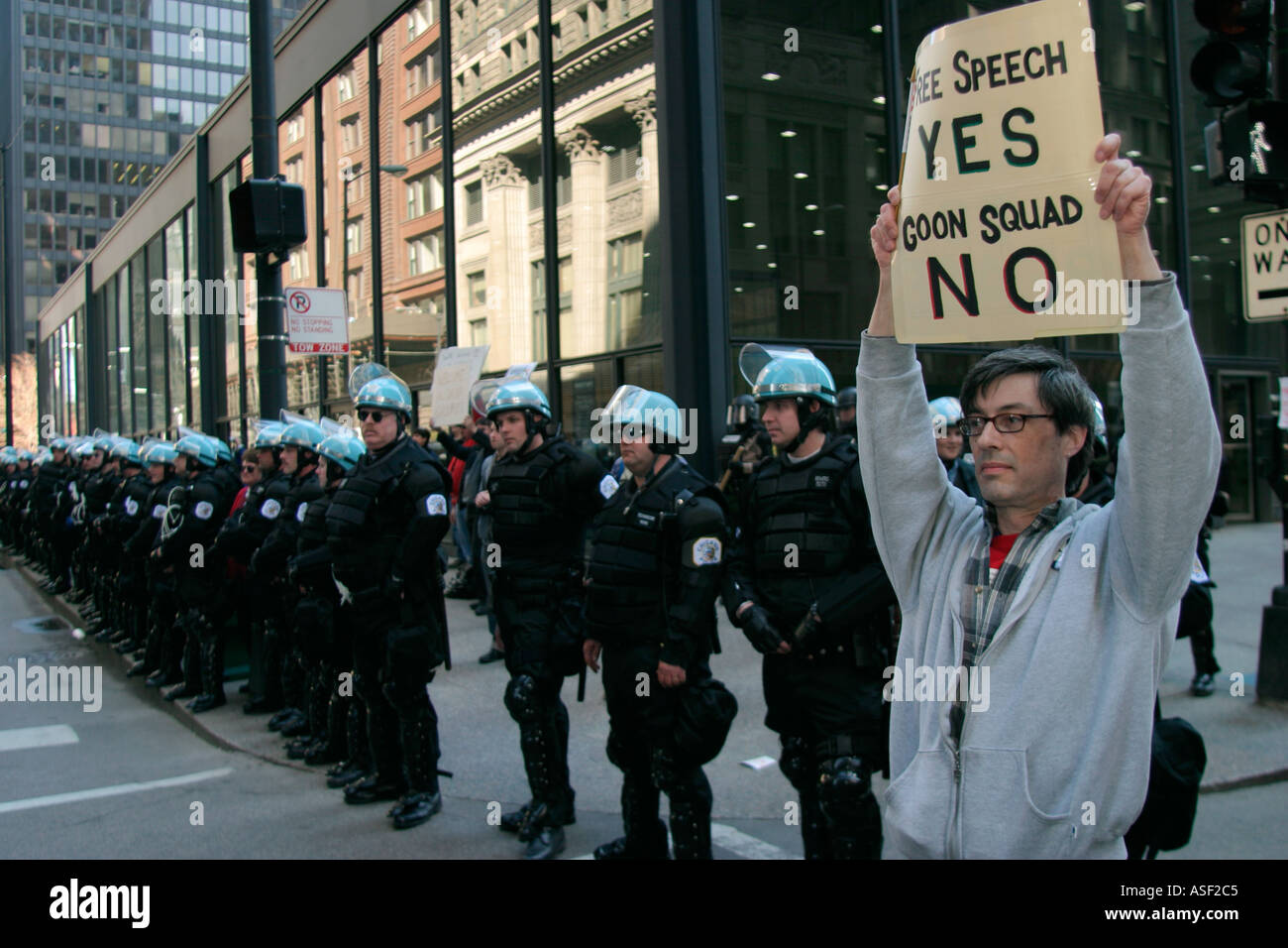 Un uomo proteste il pesante la presenza della polizia in una manifestazione contro la guerra in Iraq Foto Stock