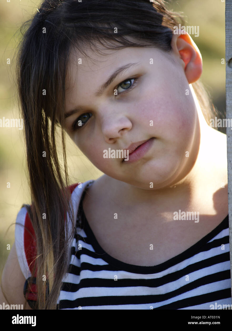 Ragazza cerca nella fotocamera, con le guance rosa e un misero aspetto sul suo viso Foto Stock