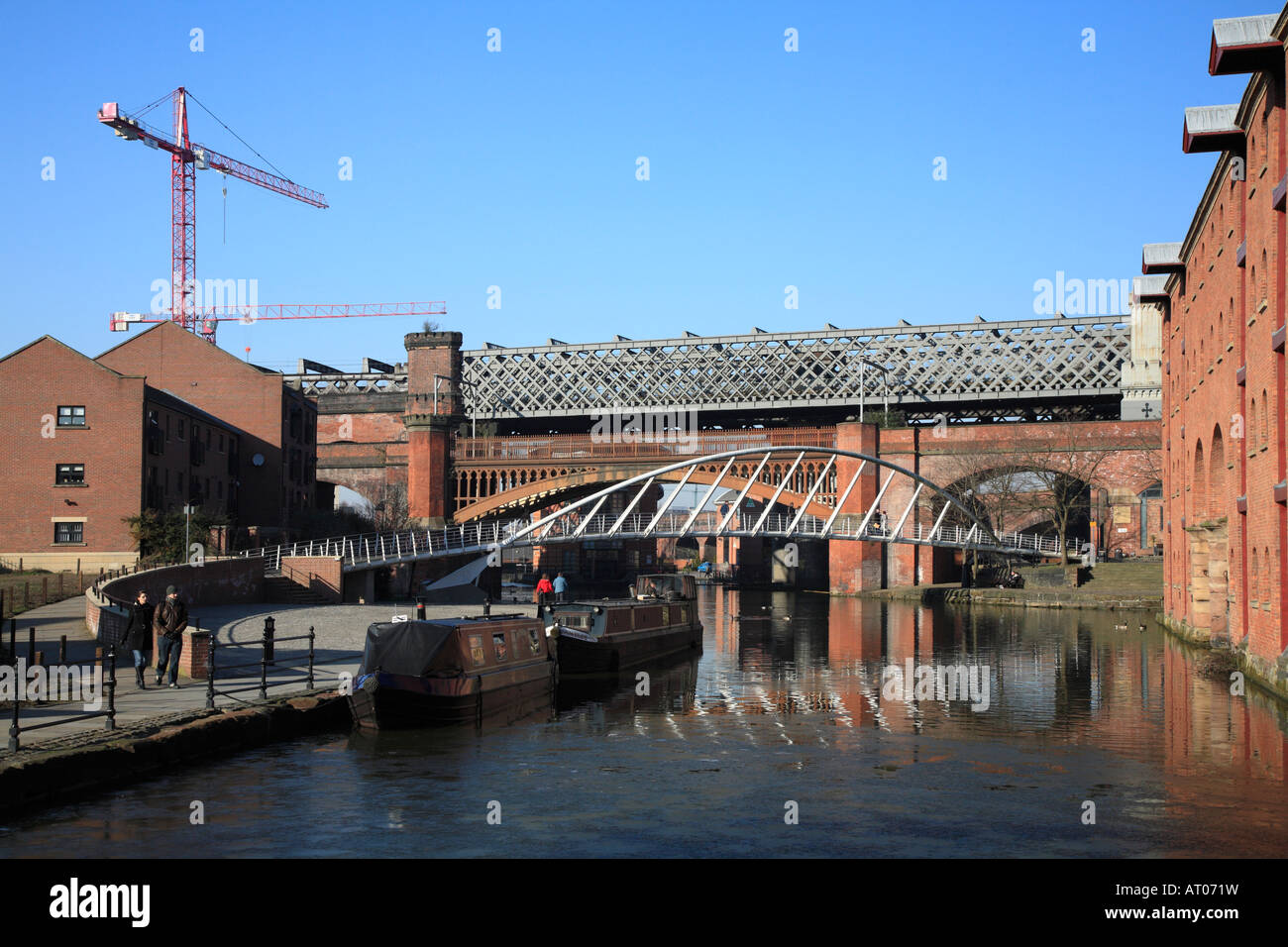 Piedino in acciaio ponte e i ponti ferroviari che attraversano la Bridgewater Canal Castlefield, Manchester, Inghilterra, Regno Unito Foto Stock