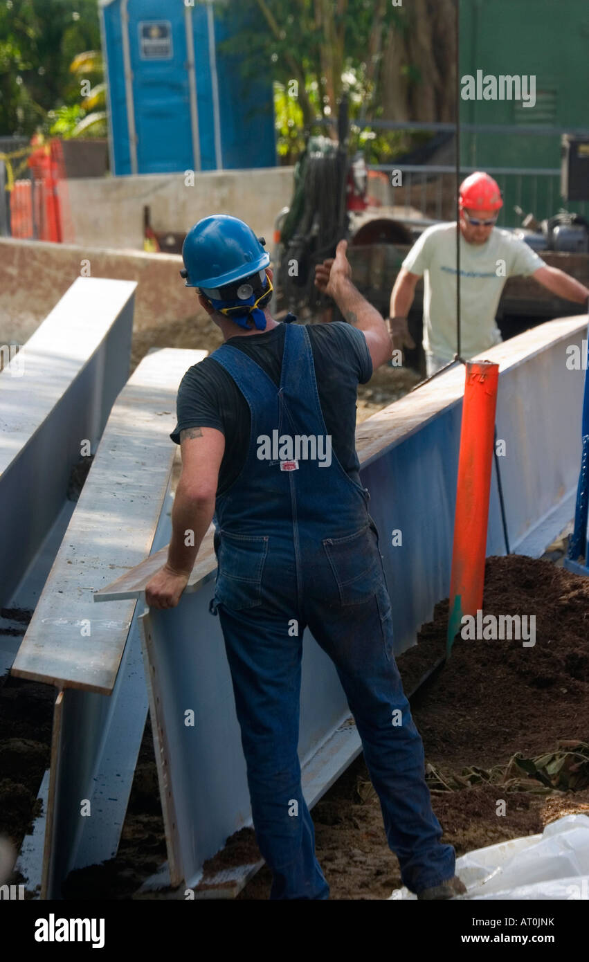 Due lavoratori nel duro cappelli mobili in acciaio Travi in posizione in corrispondenza di un sito di costruzione. Foto Stock