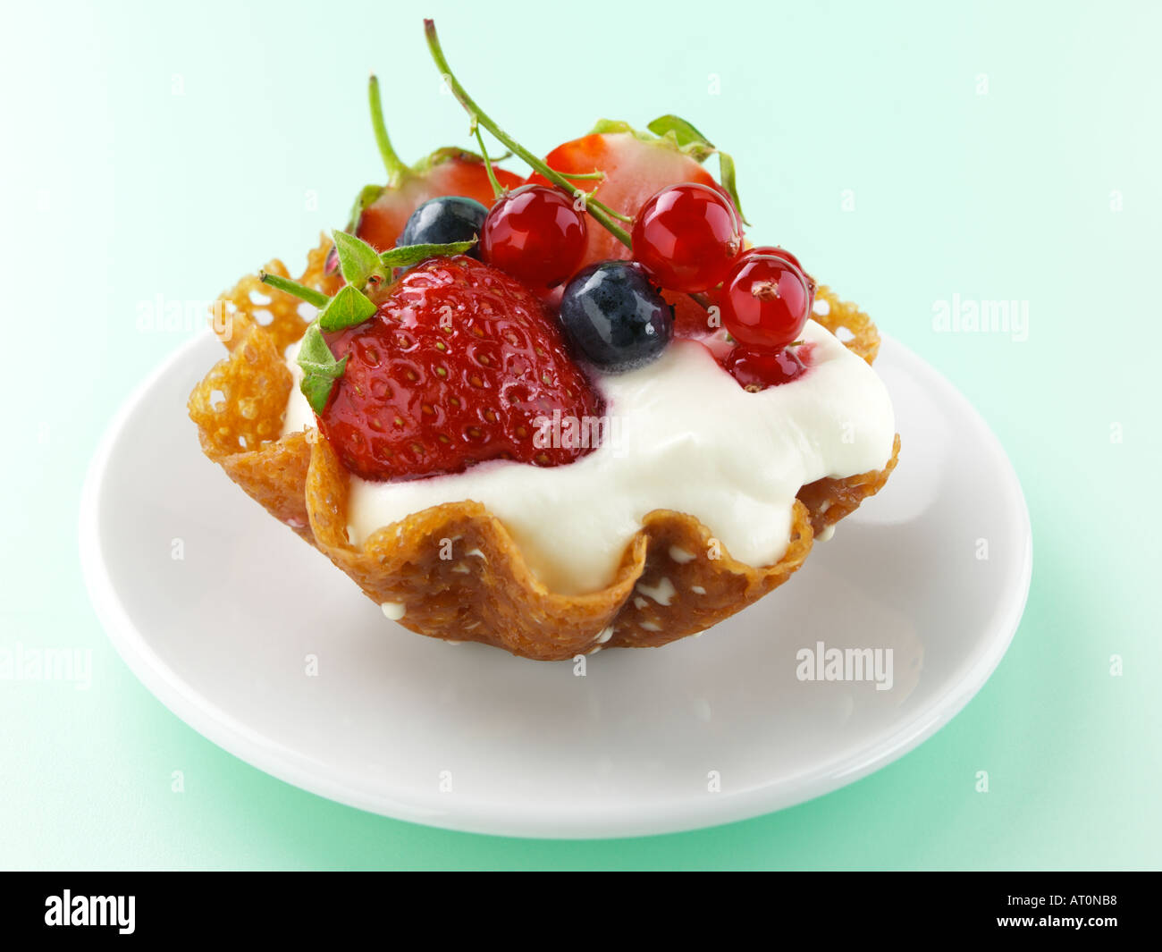 Il Brandy snap cesto di frutta fresca e crema di latte Foto Stock