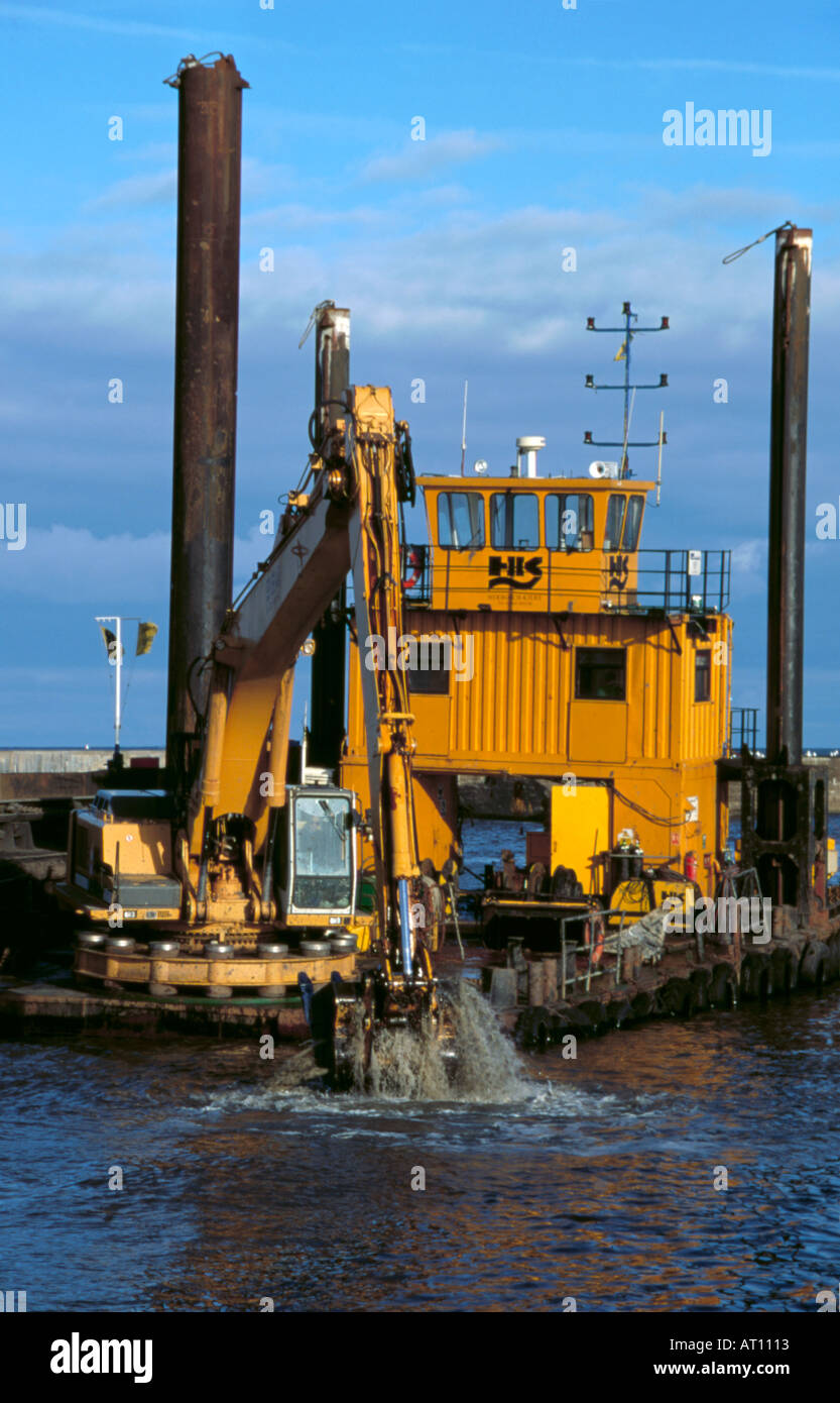 Singolo bucket draga escavatore montato su chiatta a scomparsa con tubolare in acciaio di stabilizzatori di pelo camminare Northumberland England Regno Unito Foto Stock