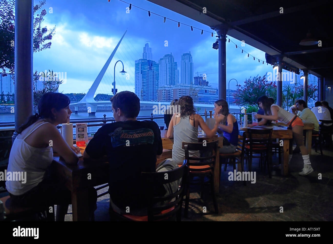 I giovani godono presso un bar a Puerto Madero Docks, appena di fronte Calatrava 's ponte della donna. Buenos Aires, Arg. Foto Stock