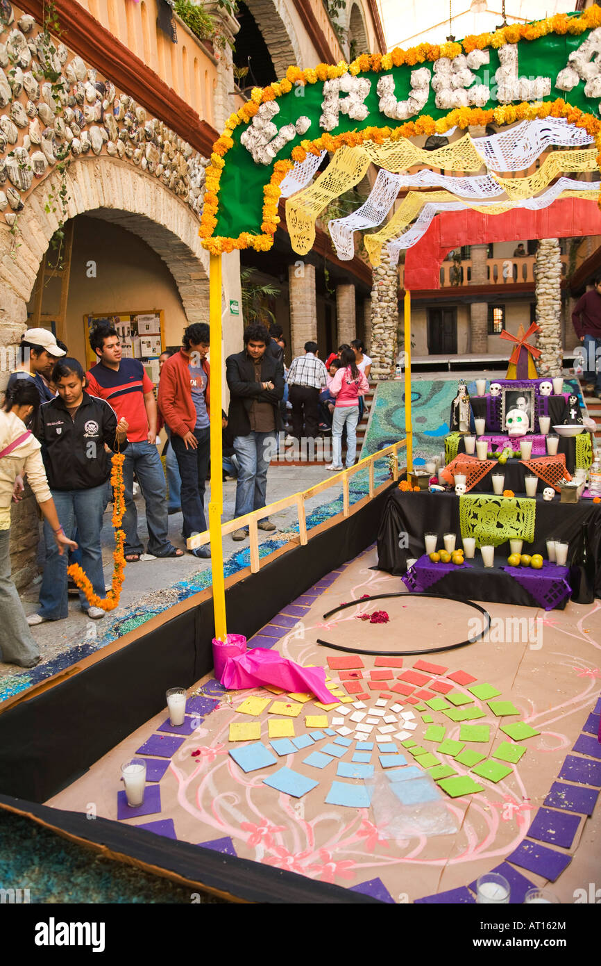 Messico Guanajuato alta scuola gli studenti a preparare il Giorno dei Morti santuario come una barca di carta colorati candele e teschi Foto Stock