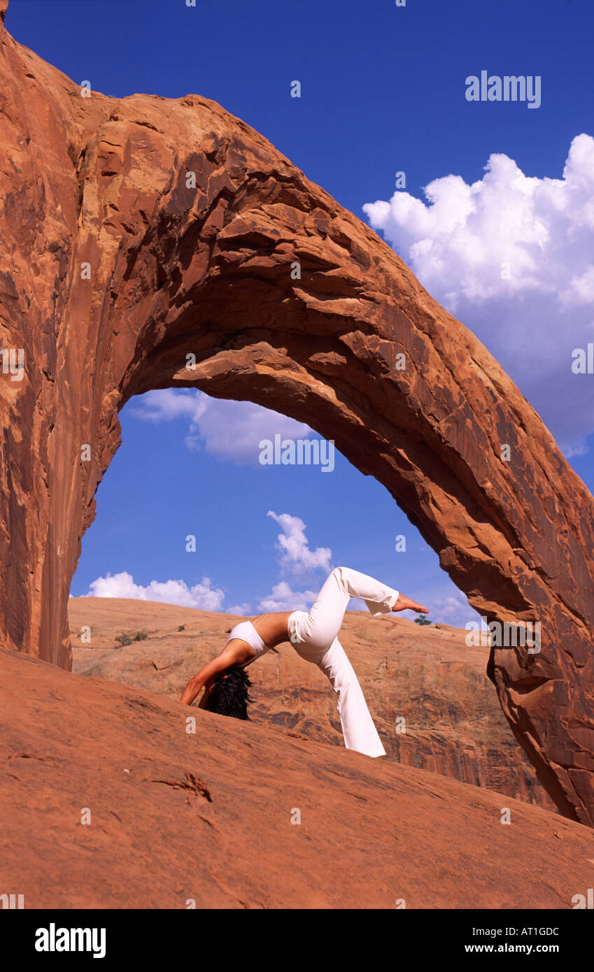 Giovane donna pratica lo yoga sotto un arco gigante USA Utah Foto Stock