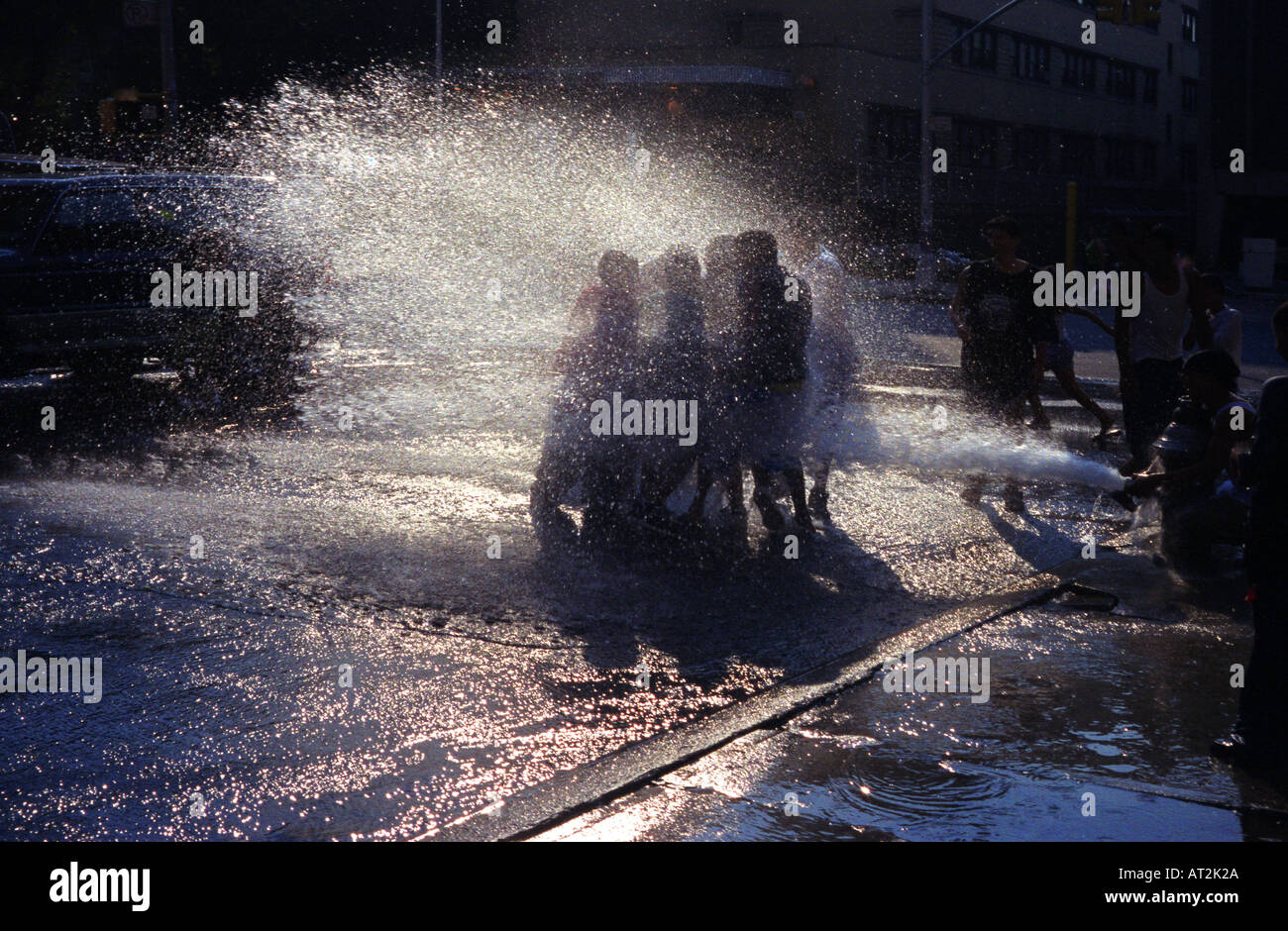 Locali i giovani ispanici in New York City s Spanish Harlem rinfrescarsi nelle calde giornate estive di spruzzo da un aperto idrante di fuoco Foto Stock