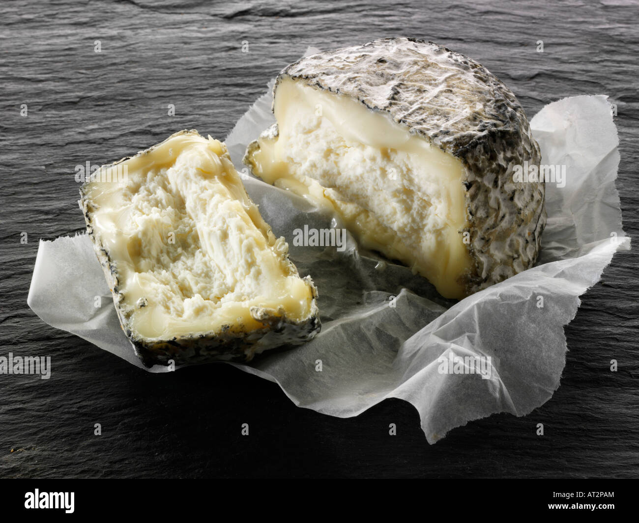 Gli agricoltori francesi di cenere Formaggio di capra tagliato su uno sfondo nero. Normandia Foto Stock