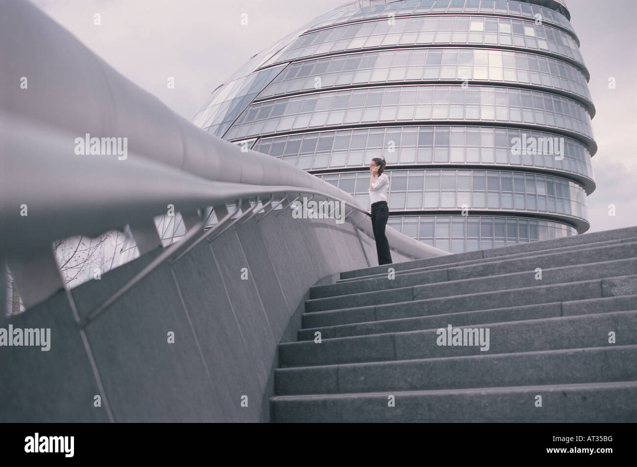 Una giovane donna al di fuori di Londra City Hall, a parlare su un telefono mobile Foto Stock