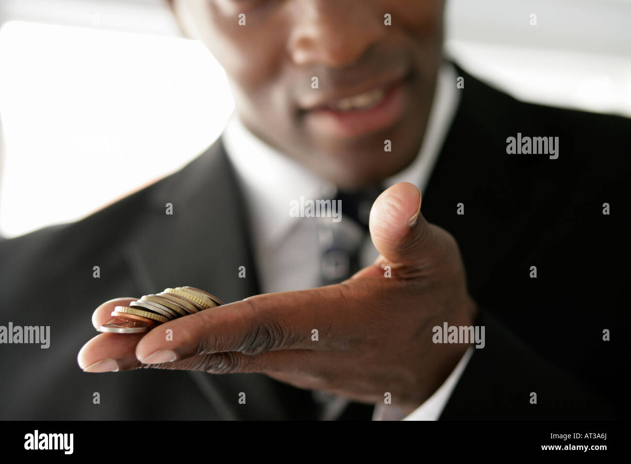 Un uomo d affari con una manciata di monete Foto Stock