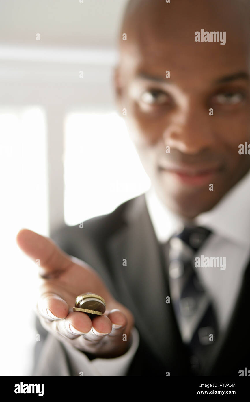 Un business man tenere una manciata di monete Foto Stock