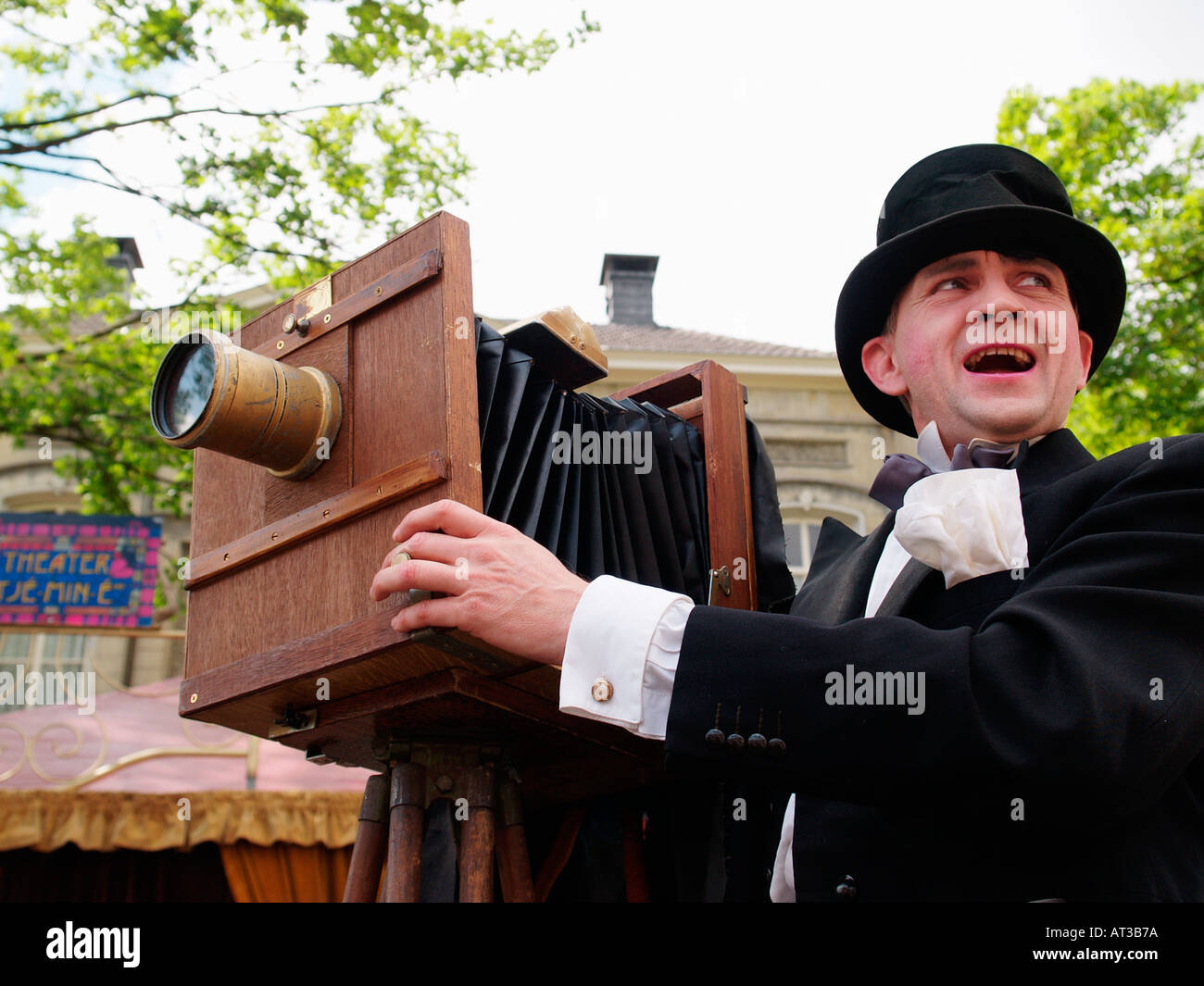 Fotografo in abito nero e hat usando una vecchia grande legno fotocamera a un festival di teatro di Breda Paesi Bassi Foto Stock