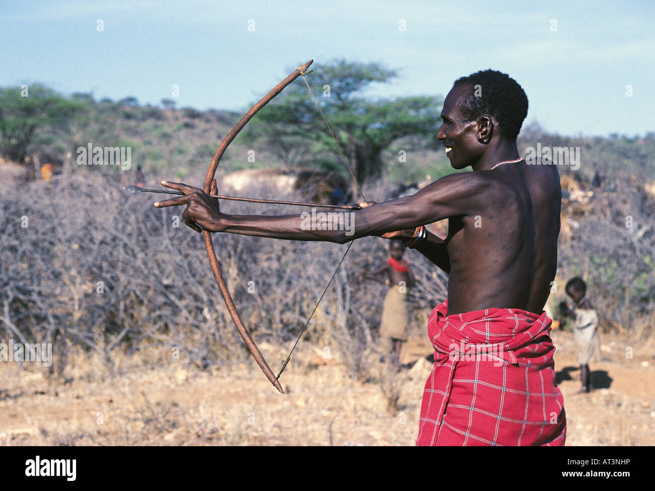 Samburu uomo preparando a fuoco un arco e frecce nei pressi di Samburu Riserva nazionale del Kenya Africa orientale Foto Stock