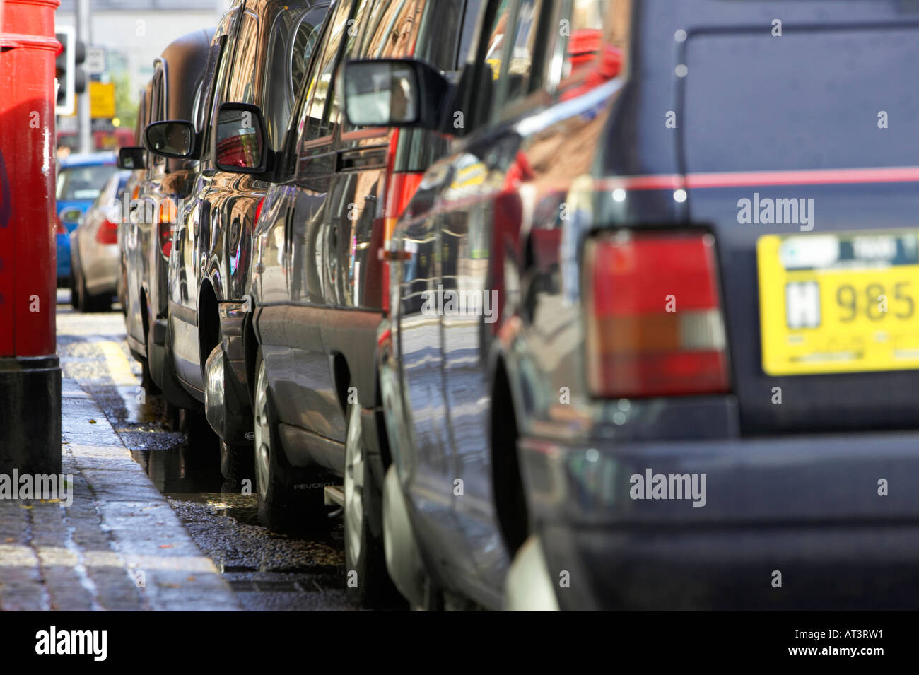 Fila di nero hackey Londra trasporto taxi su un rango accanto al cordolo in Belfast City Centre Foto Stock