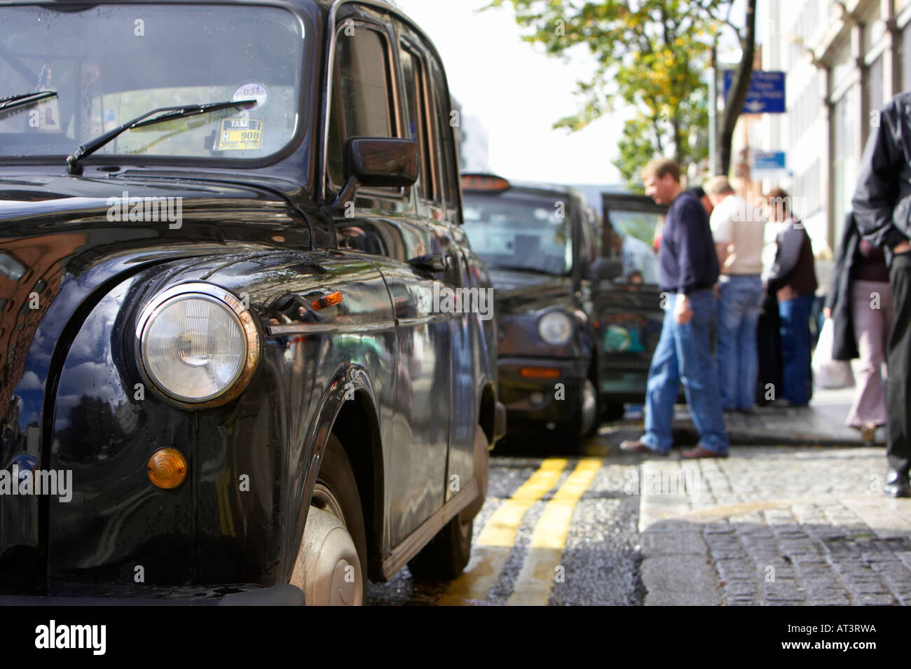 Fila di nero hackey Londra trasporto taxi su un rango in Belfast City Centre Foto Stock