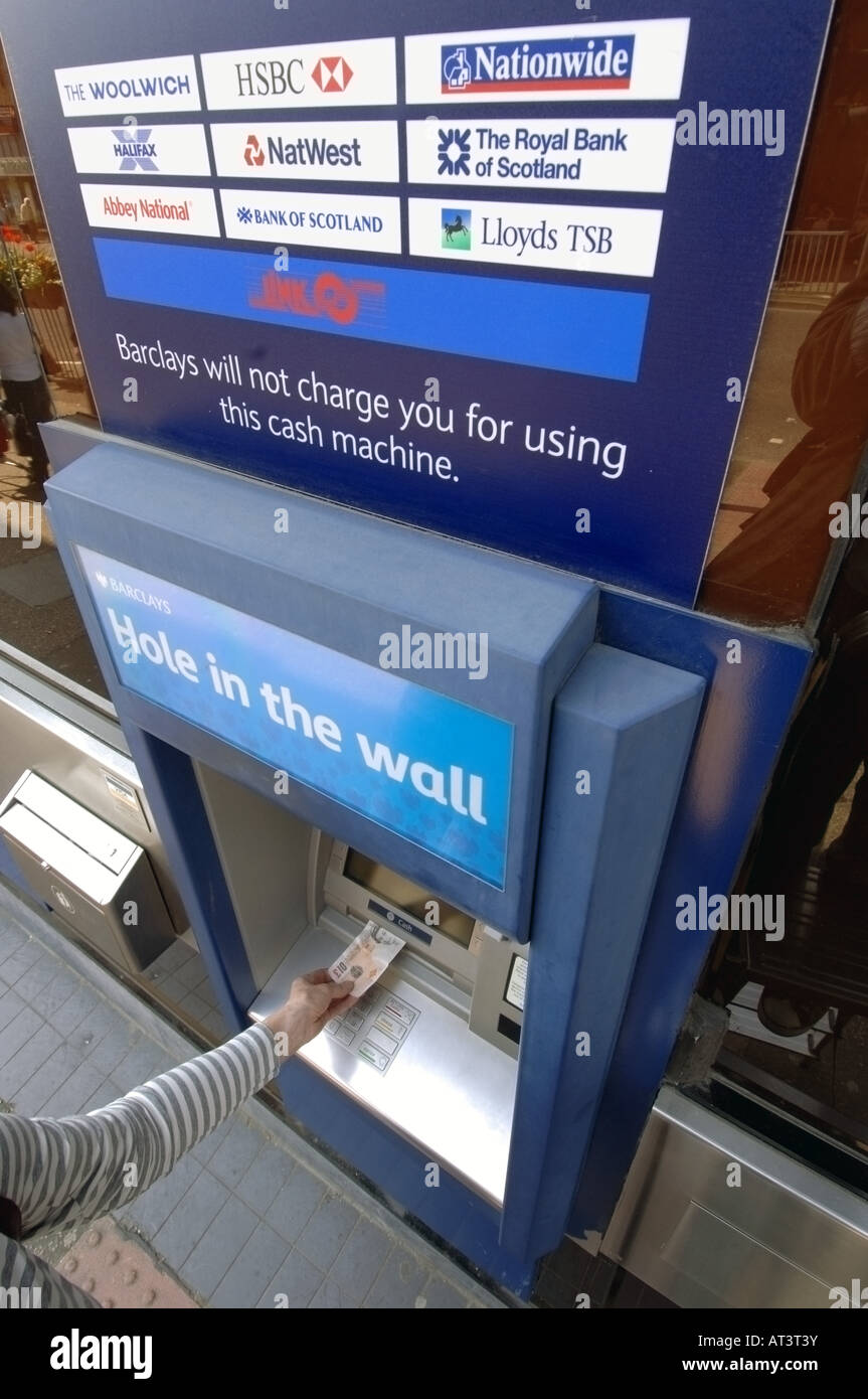 Un Barclays Bank foro nella parete bancomat con qualcuno di ritirare denaro contante Foto Stock