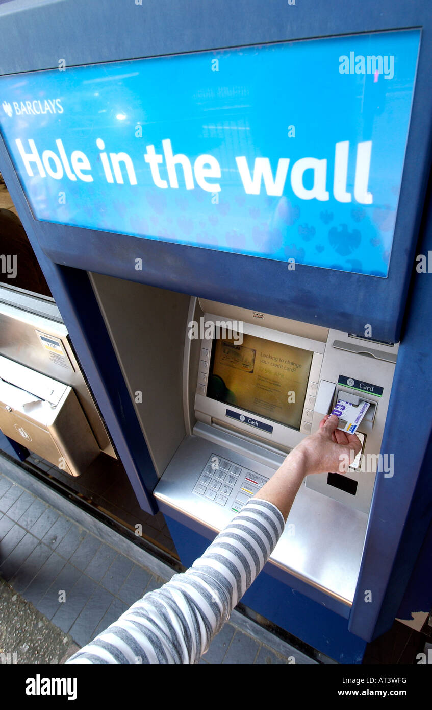 Un Barclays Bank foro nella parete bancomat con qualcuno di mettere una scheda nello slot Foto Stock