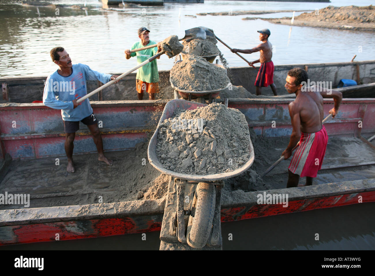 Poveri scavare sabbia dal fondo del fiume e trasportarla con canoe al litorale e venderlo agli imprenditori Foto Stock