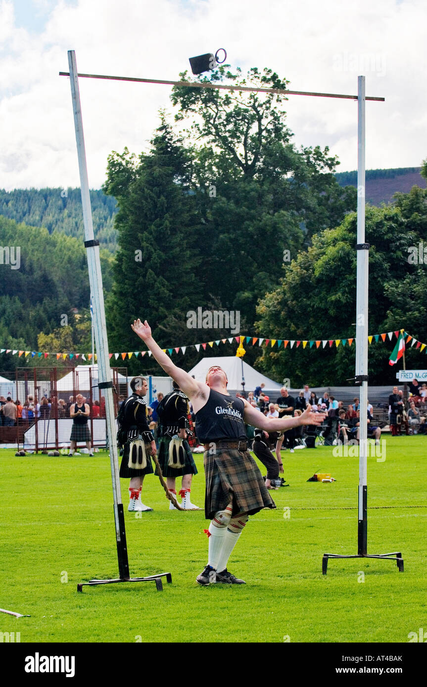 Lonach Highland Games a Strathdon, Grampian, Scozia. Concorrente indossando il tradizionale kilt gettando 56libbre di peso al di sopra del bar Foto Stock
