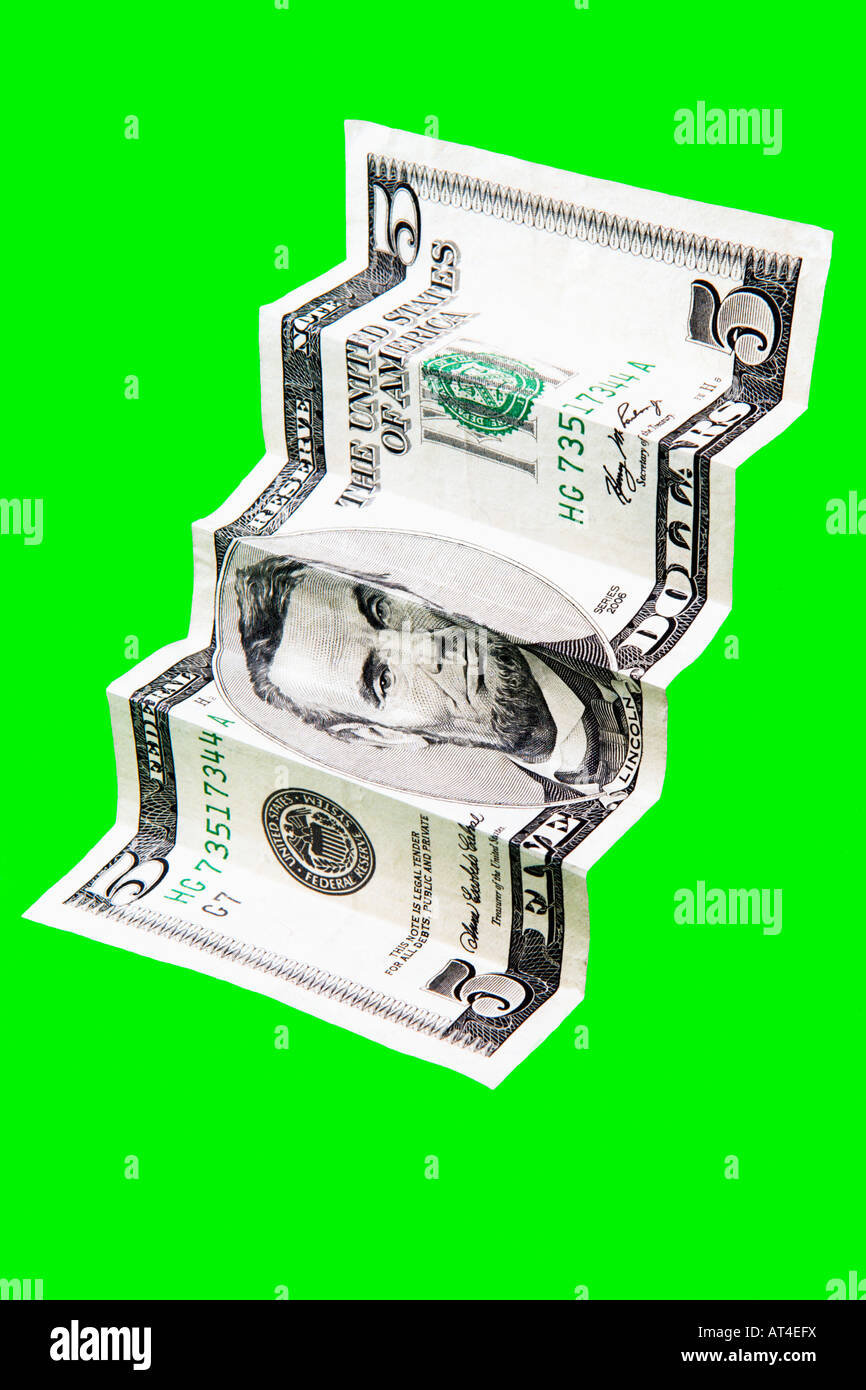 Cinque Dollari ripiegato per simulare le scale contro uno sfondo verde Foto Stock