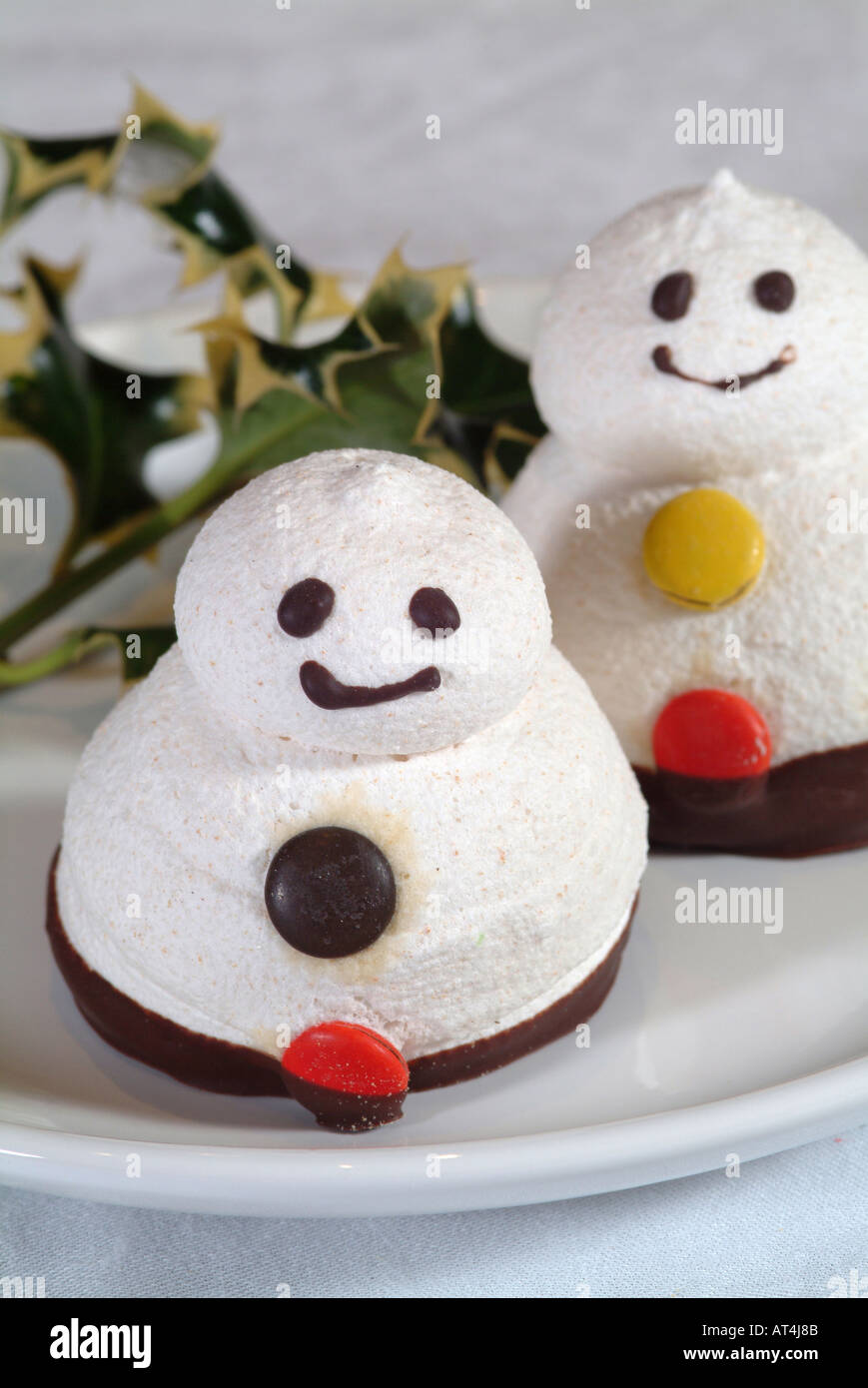 Meringa pupazzi di neve con volti sorridenti e pulsanti di cioccolato realizzati per il Mercato di Natale Foto Stock