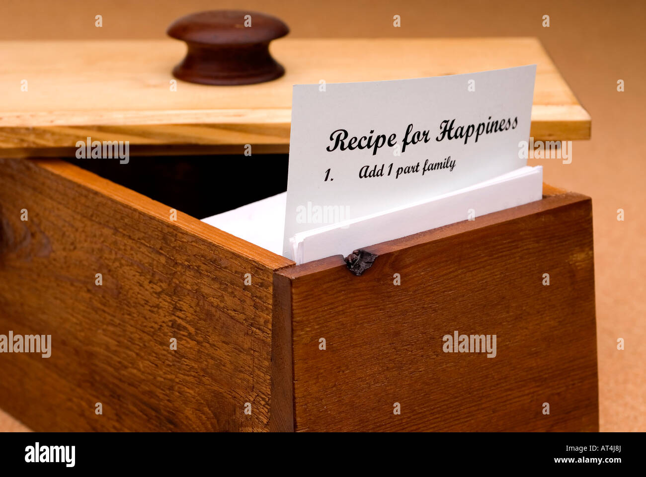 Un concetto di una ricetta per la felicità contenute su una scheda di ricetta in un ceppo di legno recipe box Foto Stock