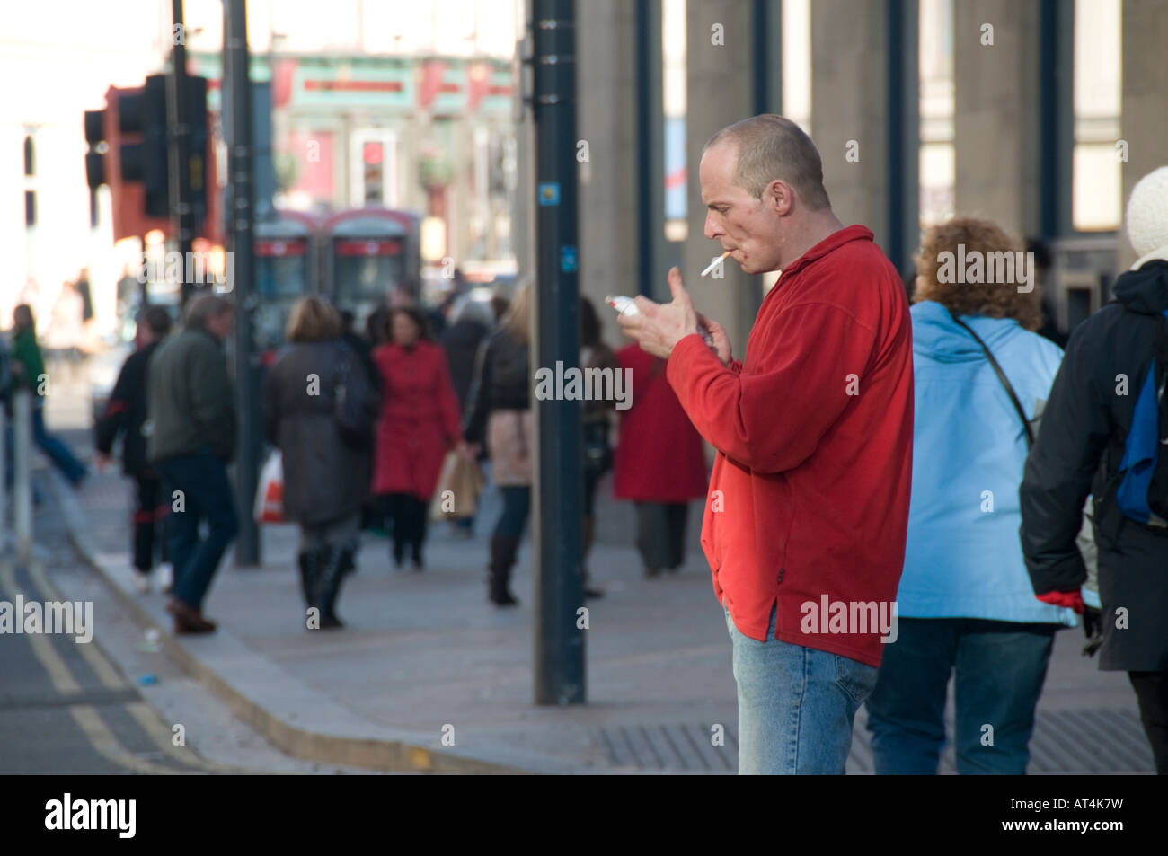 Uomo di illuminazione e di sigarette aventi un fumo sulla strada di Liverpool, in Inghilterra, Regno Unito Foto Stock