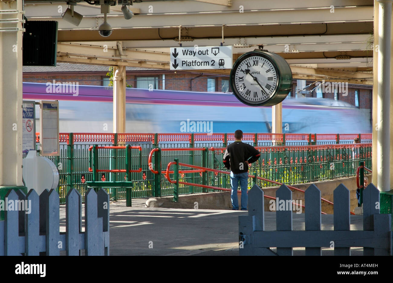 Stazione ferroviaria a Carnforth, Lancashire, Regno Unito, con la sfocatura di un treno che passa attraverso. Orologio in primo piano nel film, breve incontro Foto Stock