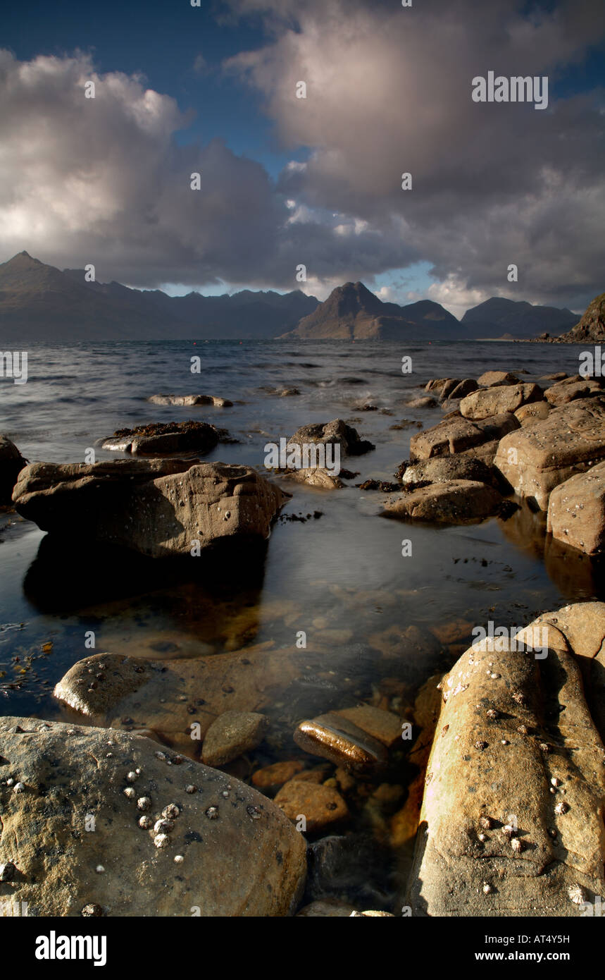 Nuvole temporalesche sopra il nero montagne Cuillin sul loch scavaig sull'isola di Skye dalla spiaggia rocciosa a Elgol village Foto Stock
