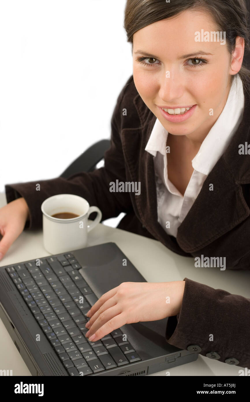 Giovane donna sorridente a lavorare con un computer in un ufficio Foto Stock