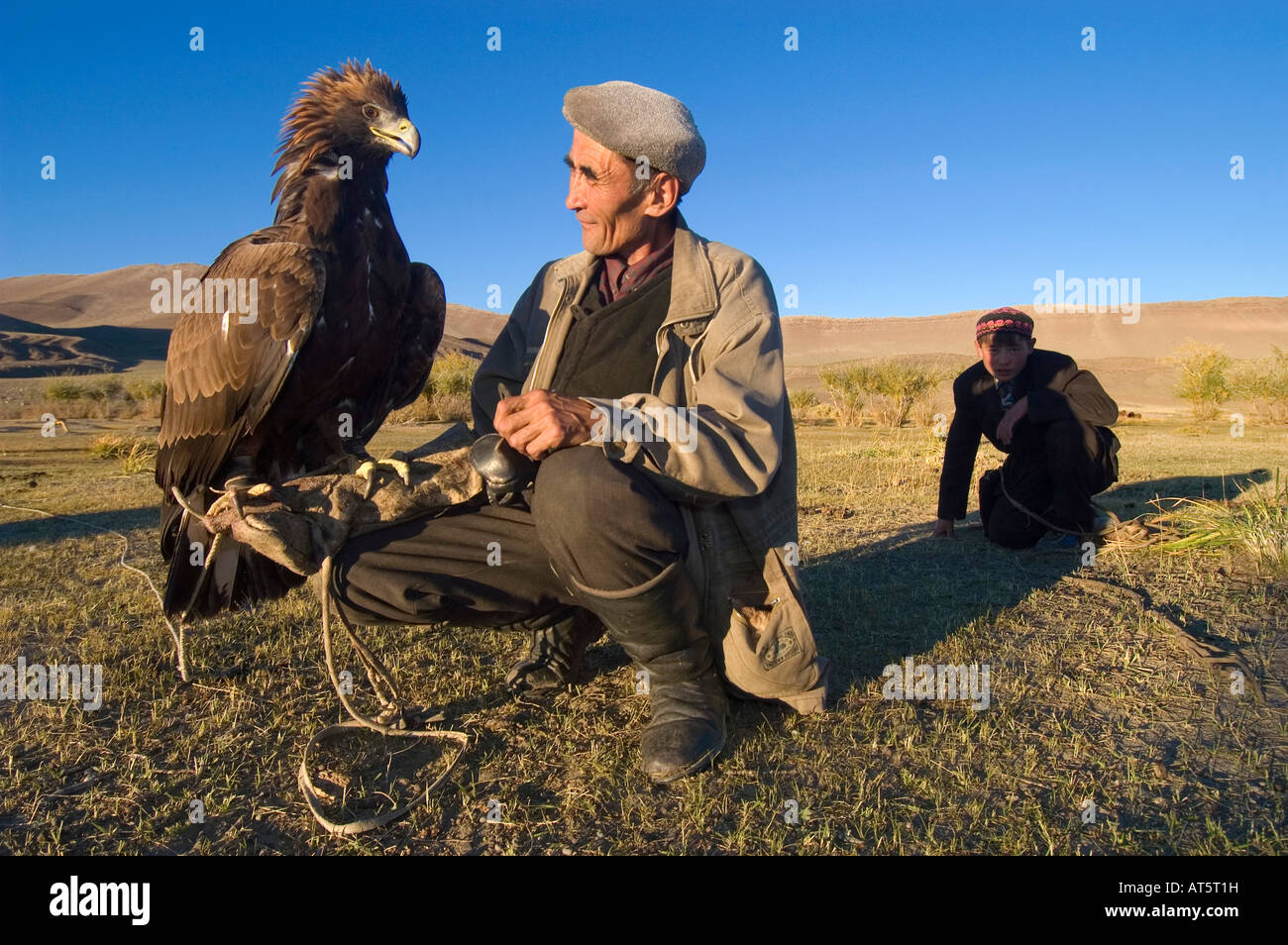 Un aquila hunter treni la sua aquila e insegna a suo figlio le antiche sport kazako di eagle caccia Bayan Olgi Mongolia Foto Stock