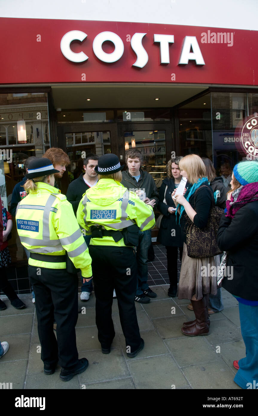 I membri di Cymdeithas yr Iaith protestando al di fuori Costa Coffee shop Aberystwyth Wales - gli ufficiali di polizia di presenze con CSO Foto Stock