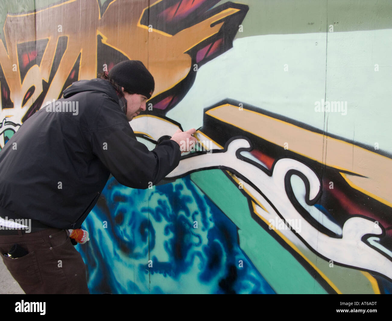 Graffiti artist verniciatura a spruzzo cantiere palizzata Liverpool Regno Unito Foto Stock