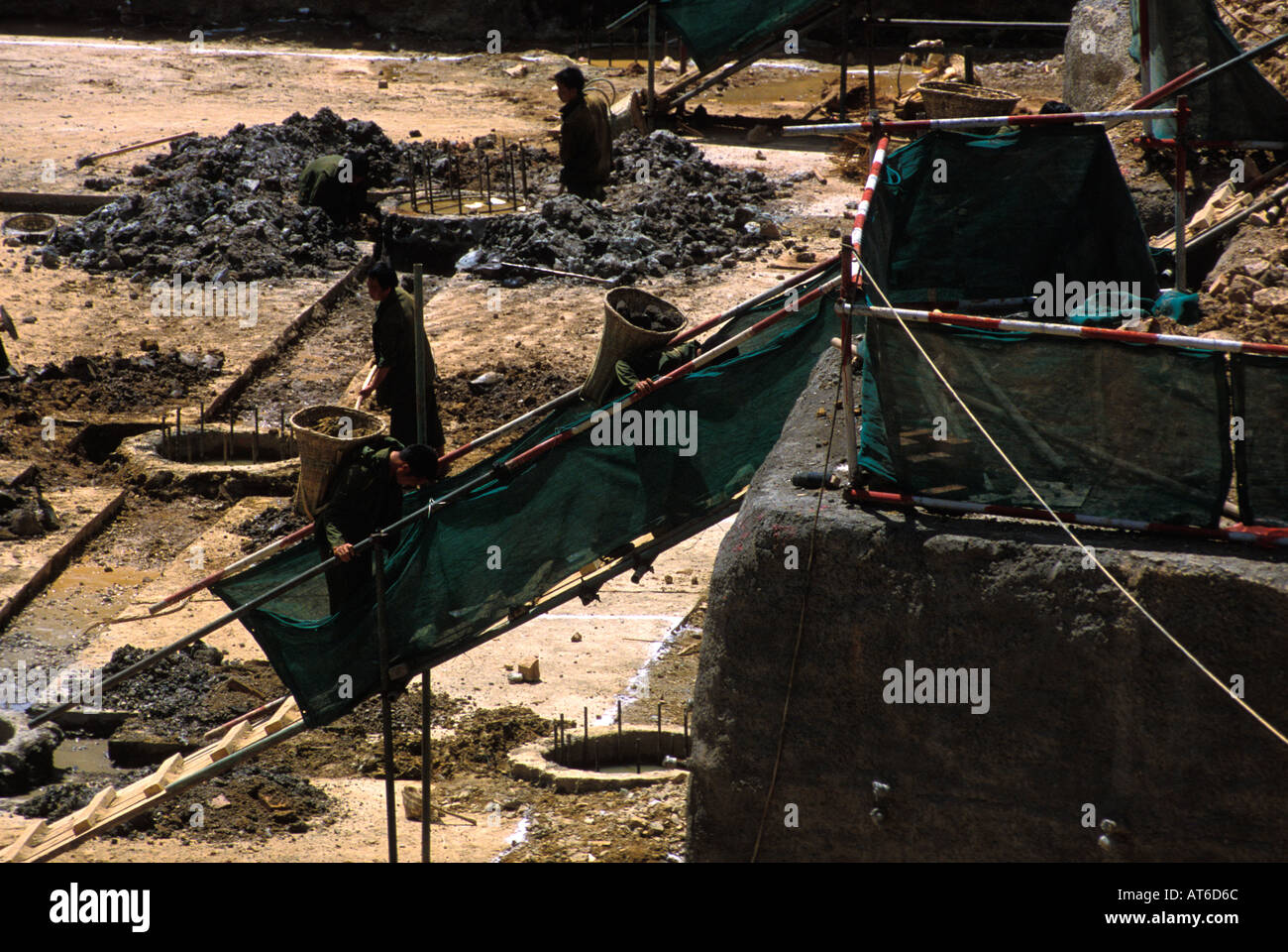 Un sito in costruzione in Kunming lavoratori utilizzando primitive cestelli di bambù per trasportare pietre sulle loro spalle Foto Stock