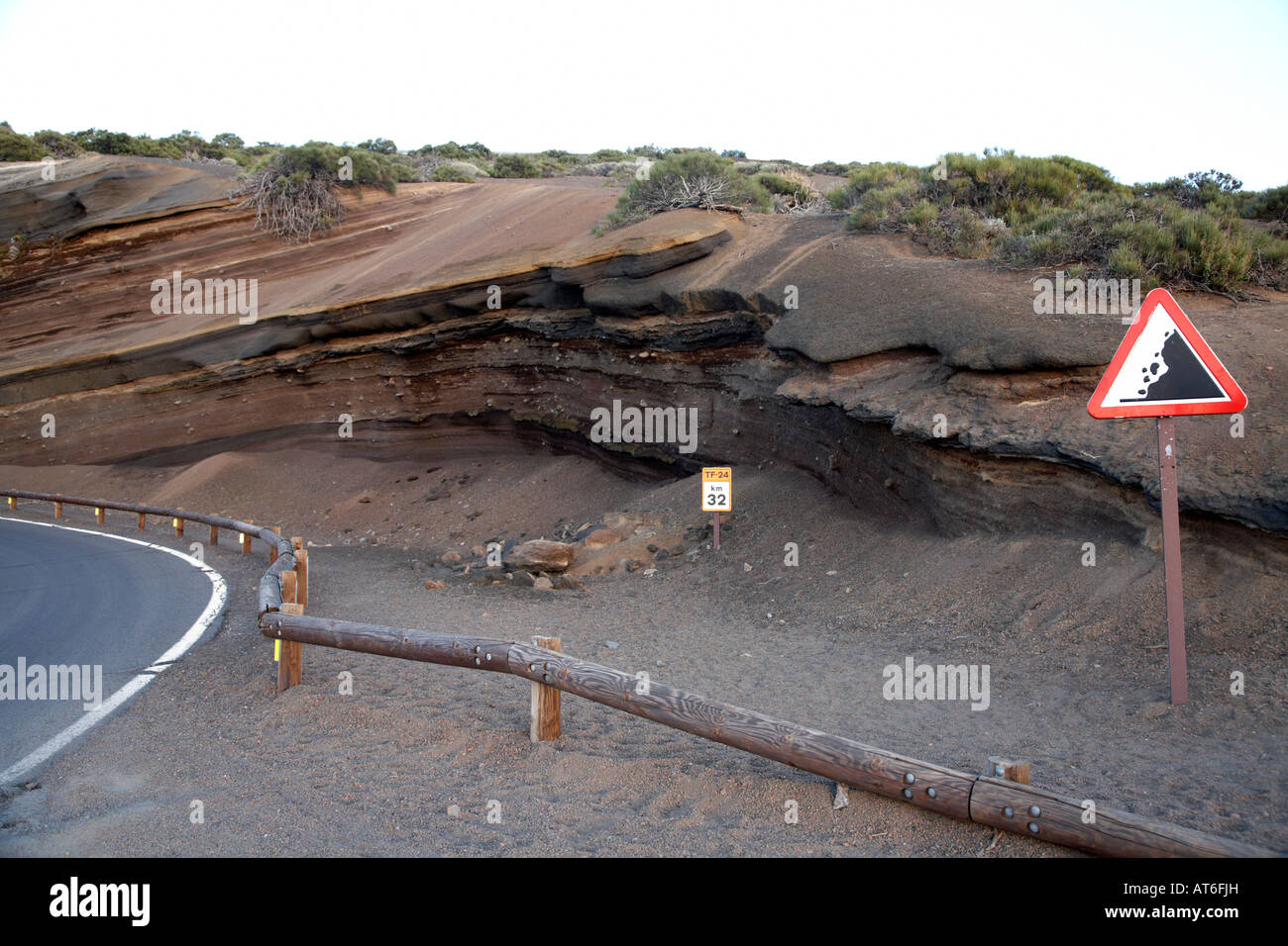 Rocce di pericolo un cartello di segnalazione e di protezione barriera di legno a la tarta formazioni di roccia vulcanica dal ciglio della strada Tenerife Canarie isl Foto Stock