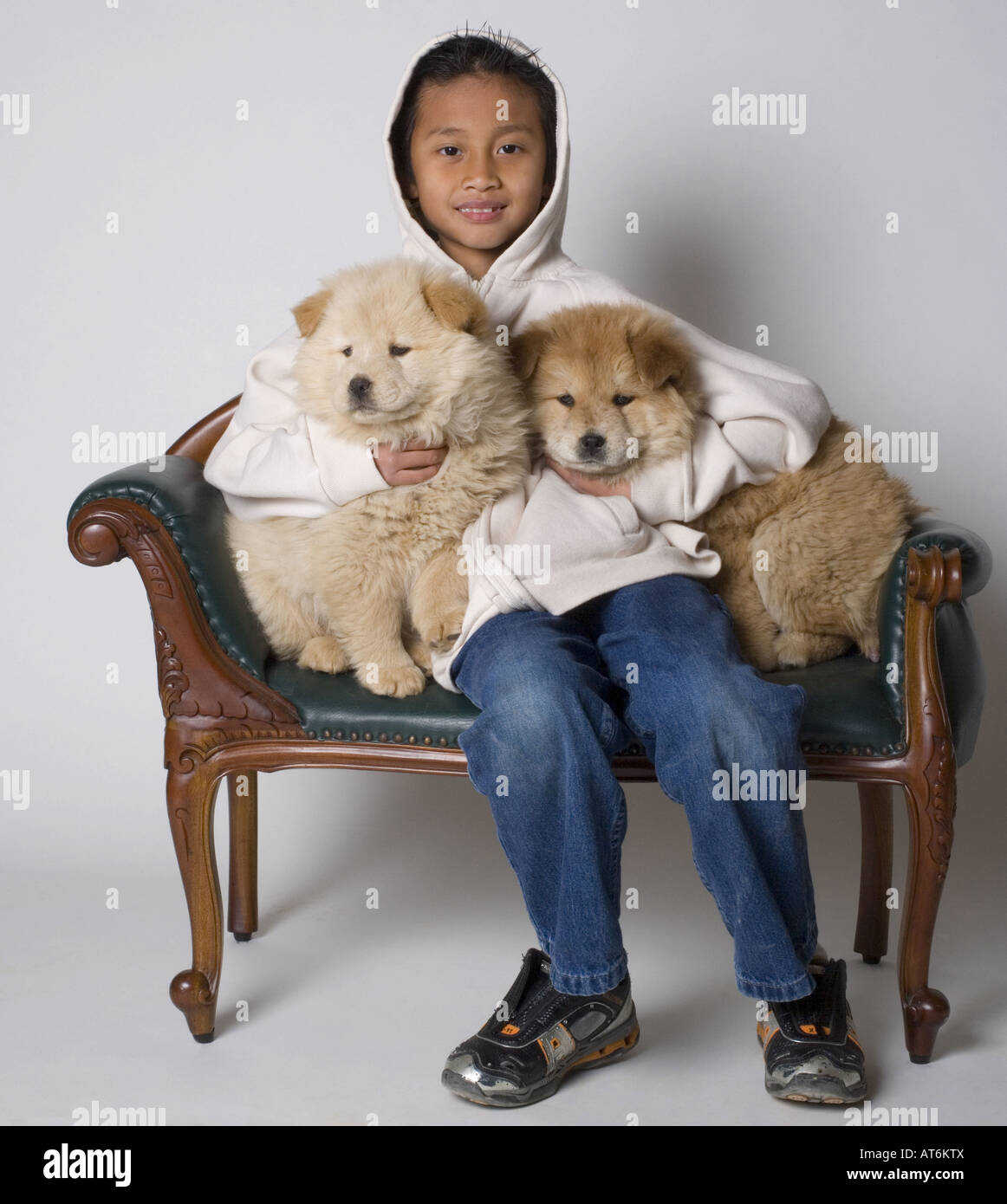 Ragazzo giovane azienda due cuccioli Foto Stock