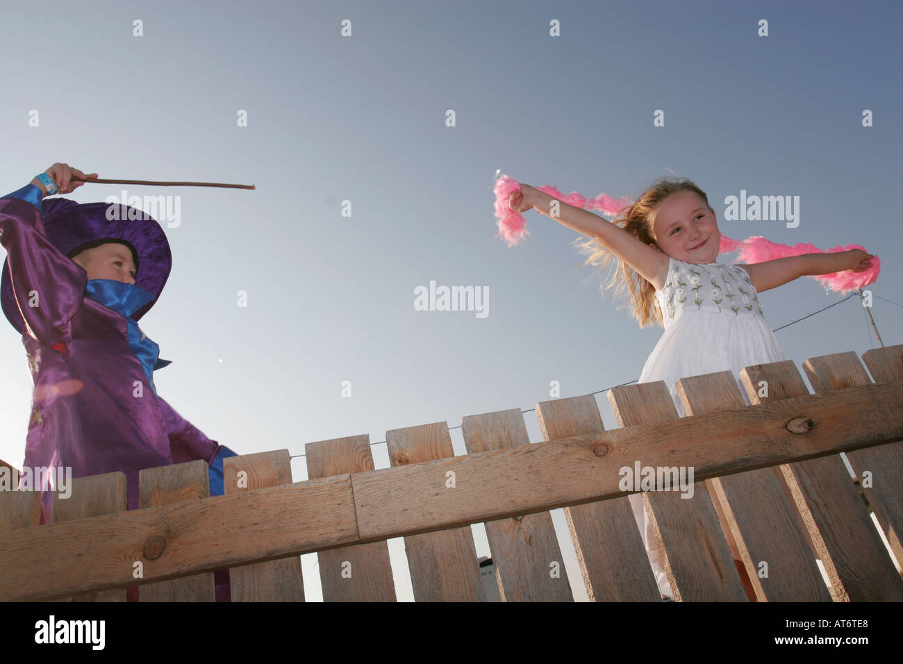 Procedura guidata ragazzo con la bacchetta magica e la ragazza bionda tenendo giù boa Foto Stock