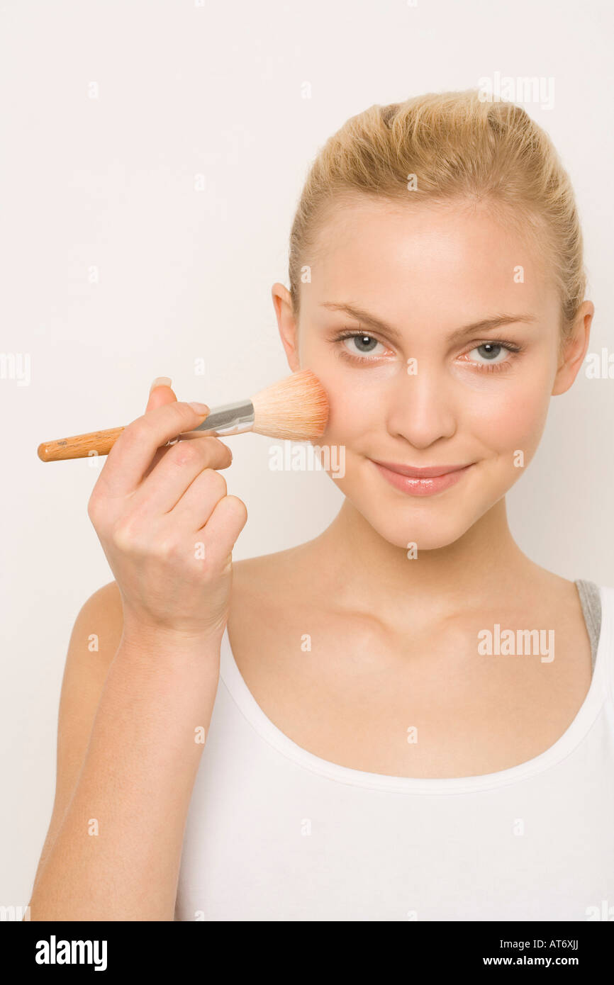 Giovane donna applicando arrossire, sorridente, ritratto Foto Stock