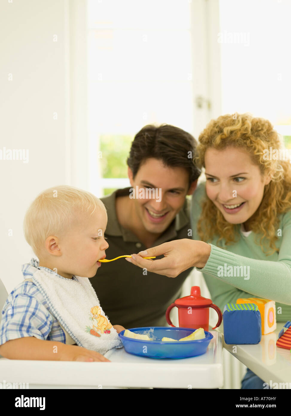 Famiglia giovane, madre alimentare baby boy (12-24 mesi) Foto Stock