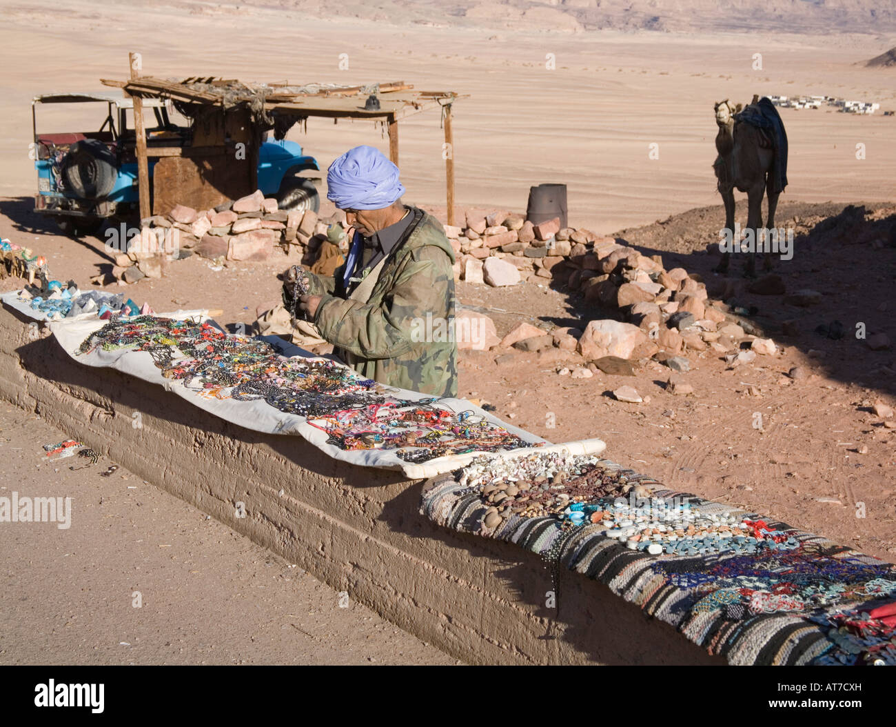 Deserto Egitto Nord Africa Febbraio un uomo beduino di smistamento di ninnoli prevista su una parete per la vendita al passaggio di turisti Foto Stock